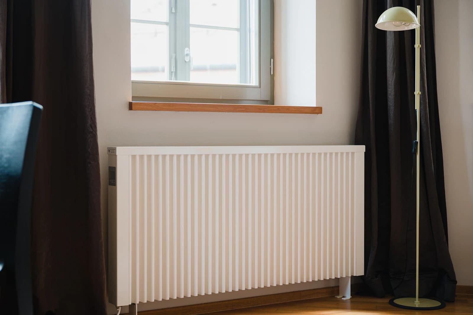 Hand ontlucht een radiator met een ontluchtingssleutel