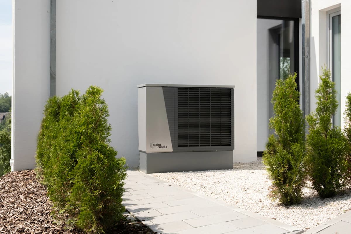 Buitenunit van een lucht-water-warmtepomp tegen een gevel