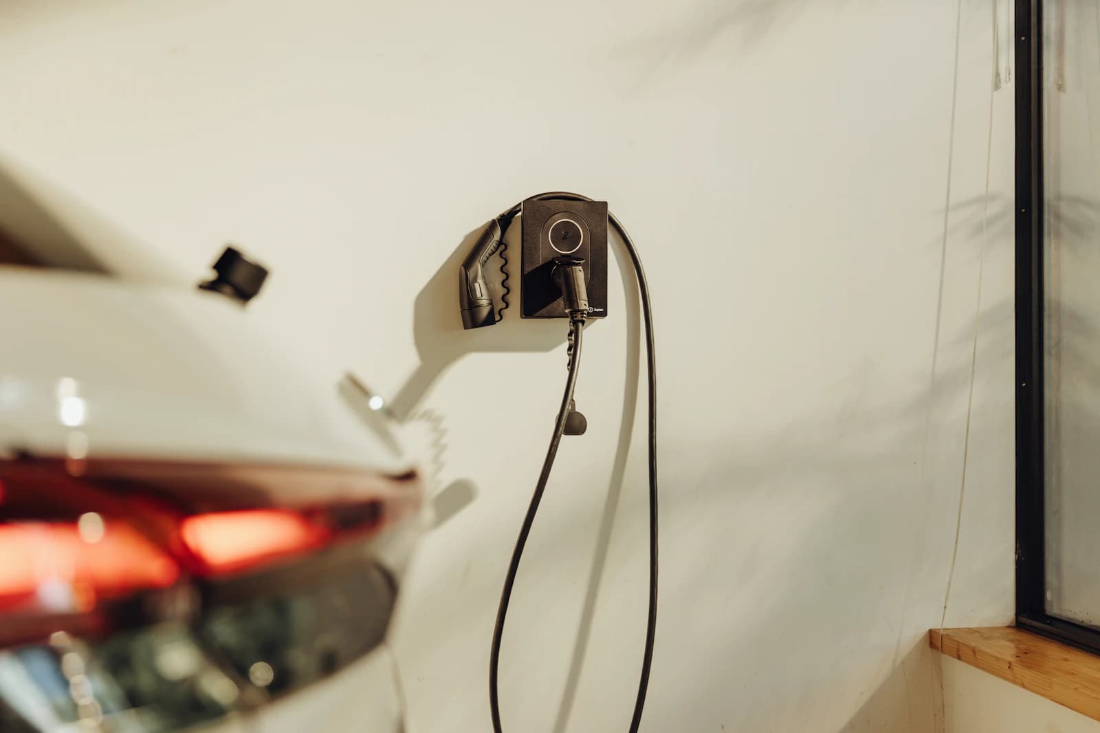 Elektrische wagen laadt op aan een laadpaal aan de oprit