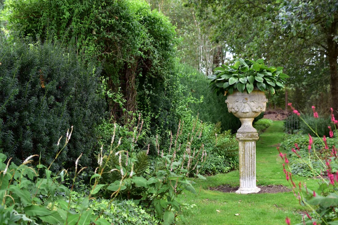 Tuinaannemer maait het gazon tijdens regelmatig tuinonderhoud