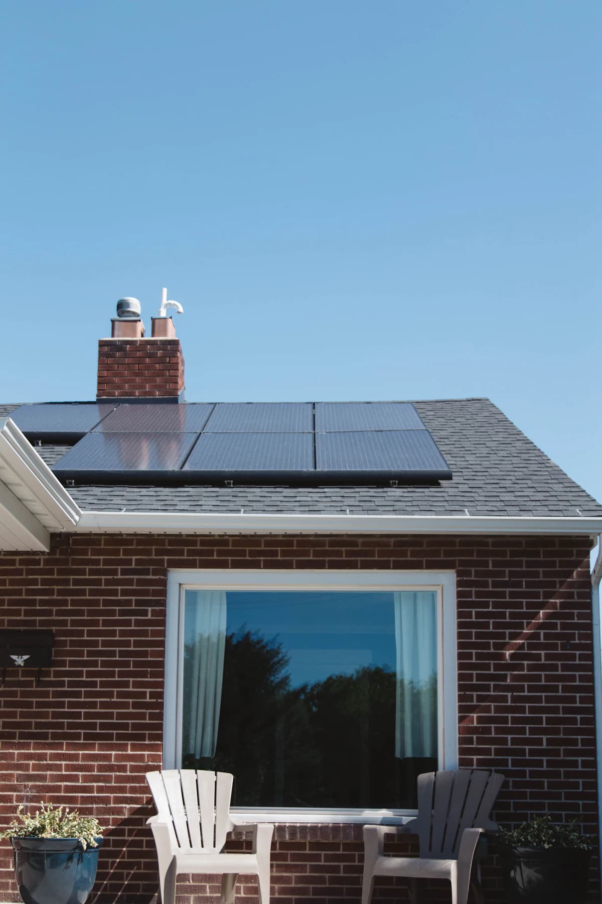 Zonnepanelen op een dak in Vlaanderen met een digitale meter die het verbruik en de piek registreert