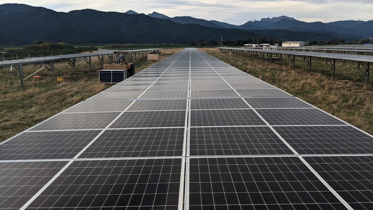 Vakman maakt zonnepanelen schoon met een telescopische borstel